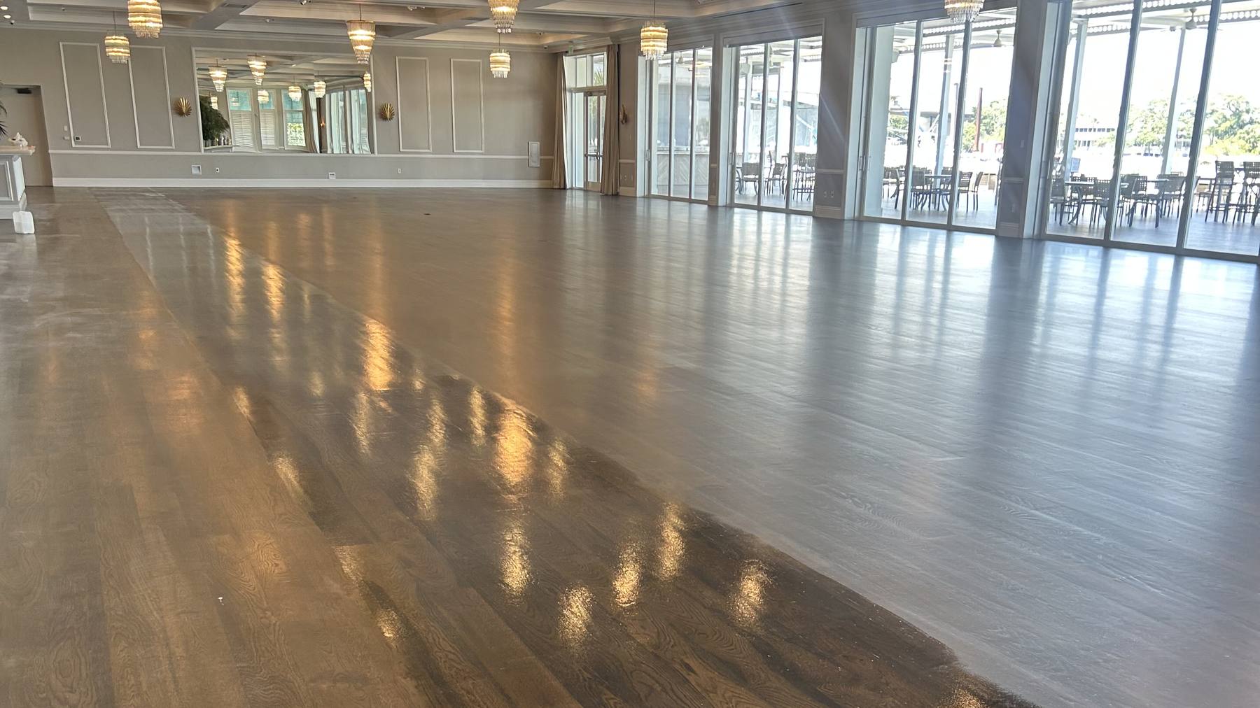 Freshly refinished dark oak floor gleaming across a Palm Beach clubhouse ballroom