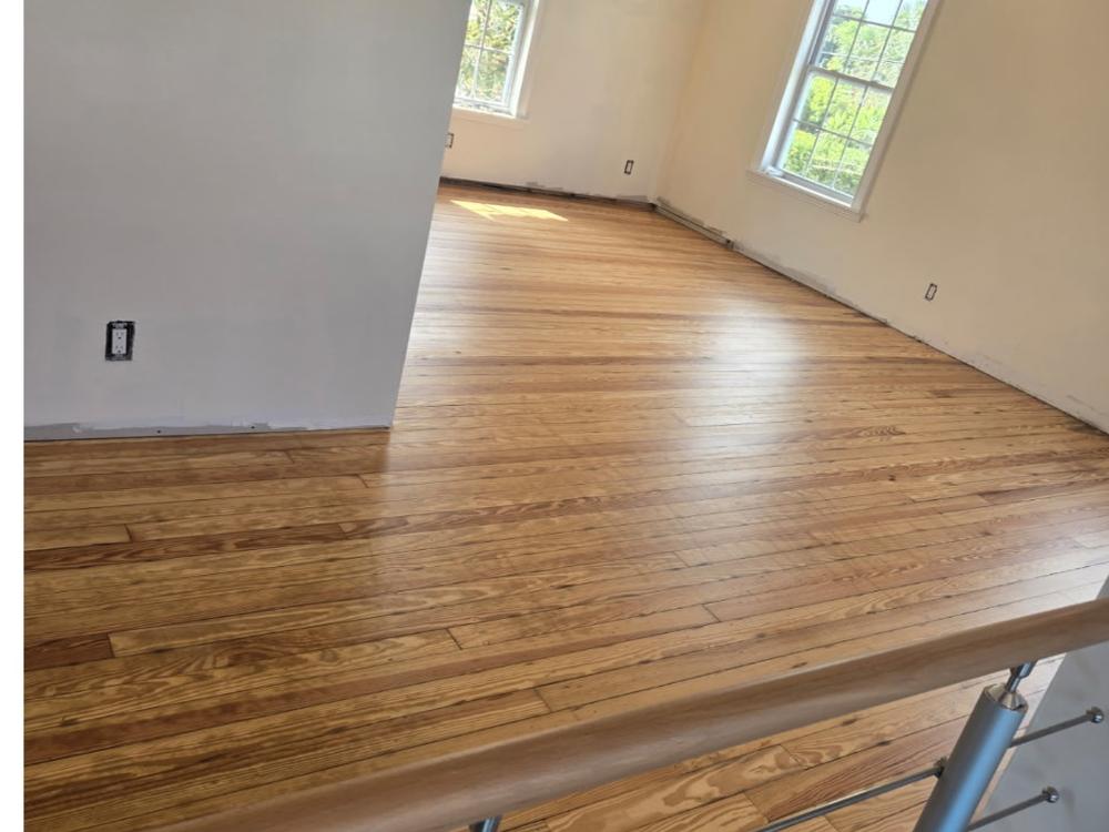 Refinished heart pine floor and stair landing with cable railing